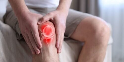 Man holding knee as in pain